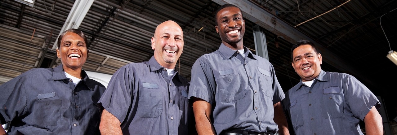 Multi-ehnic workers in service garage at trucking company.